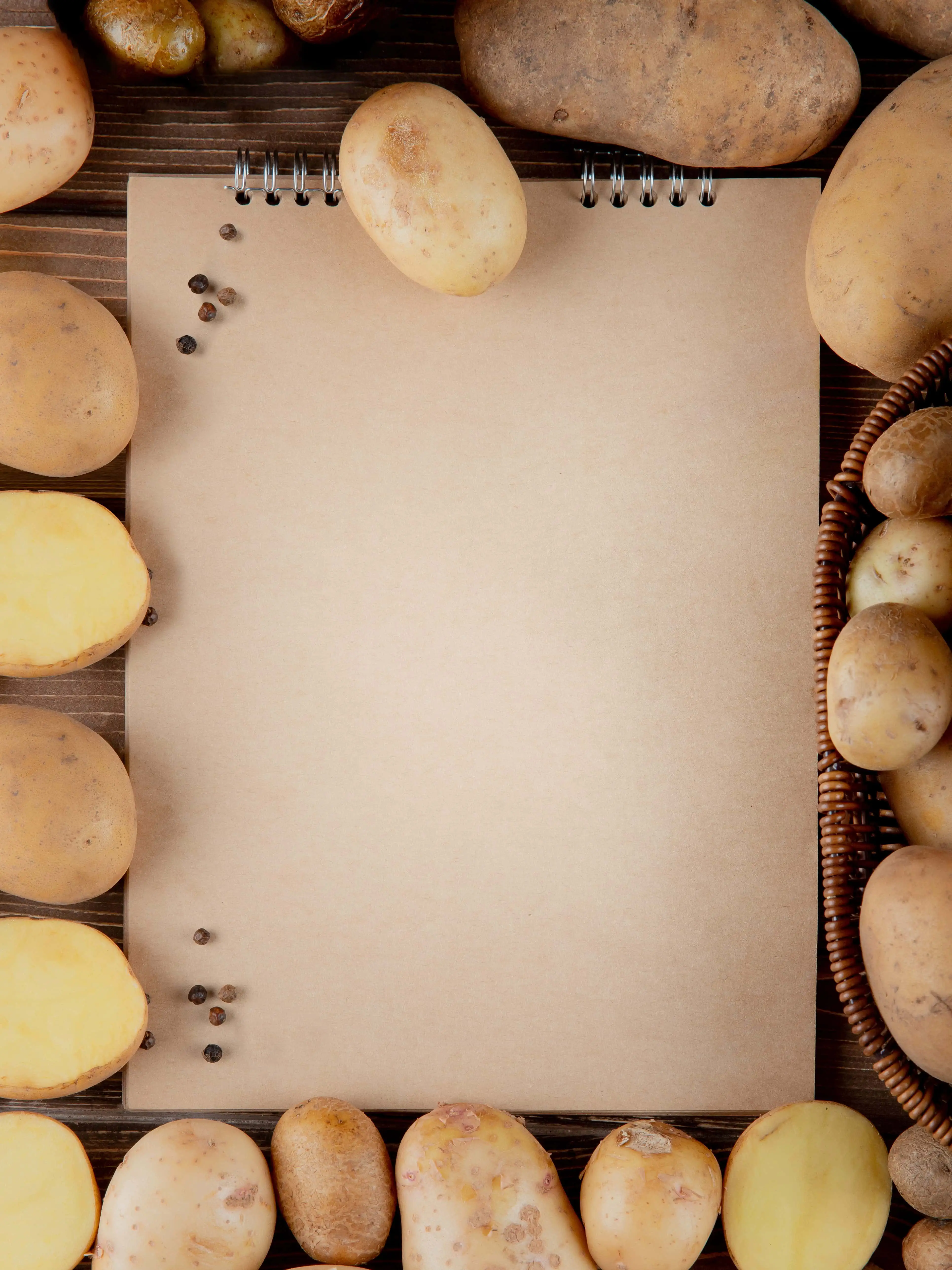 top view whole cut potato with black pepper note pad with copy space 02