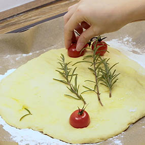 Kartoffel Focaccia Ligurisches Kartoffelbrot Fladen mit Tomaten dekorieren