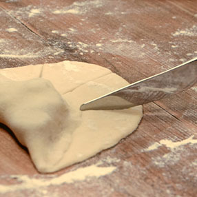Patatesli Şerit Poğaça Tuerkische Kartoffelhoernchen mit Messer einschneiden